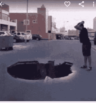 a man is standing next to a large hole in the ground