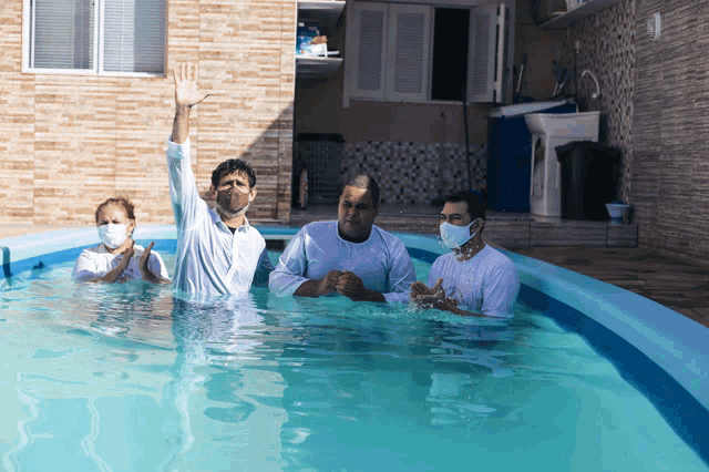 a group of people in a swimming pool with face masks on