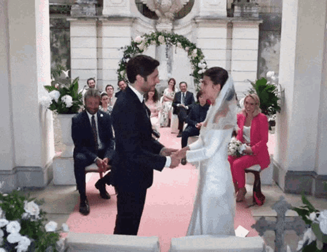 a bride and groom holding hands at their wedding ceremony