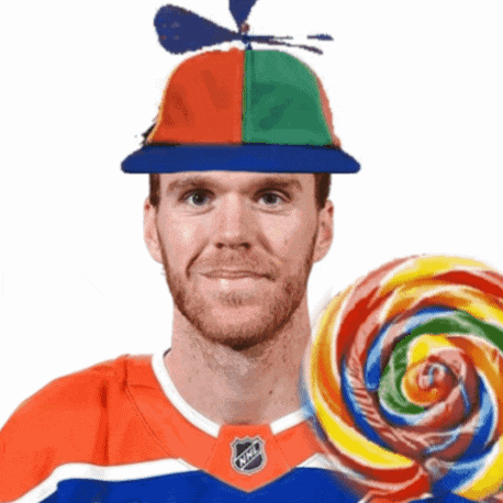 a man wearing a hat that has a propeller on it is holding a colorful lollipop