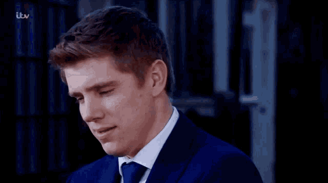 a man in a blue suit and tie is on a tv screen