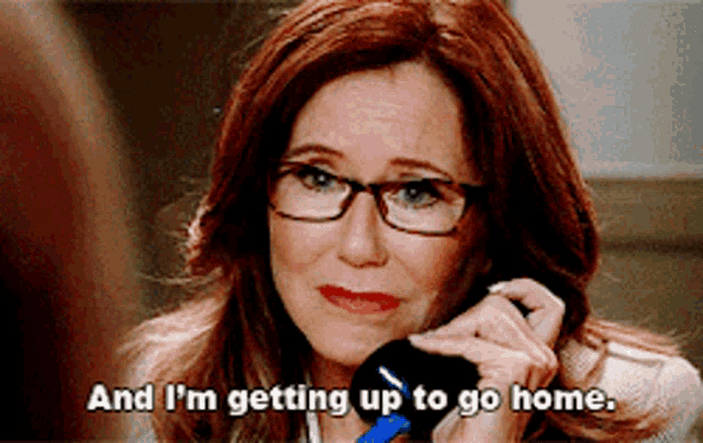 a woman with glasses is talking on a cell phone and says and i 'm getting up to go home