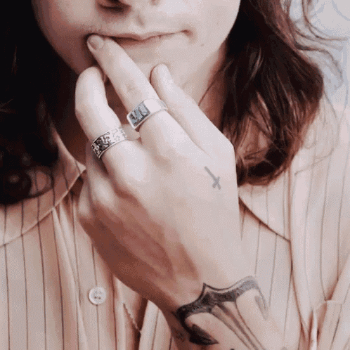 a close up of a person 's hand with a tattoo of a cross on it