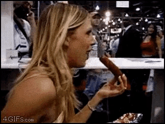 a woman is eating a hot dog with a 4gifs.com watermark on the bottom right