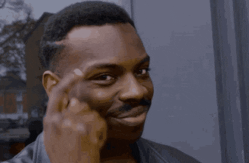 a man with a mustache is smiling and looking at the camera .