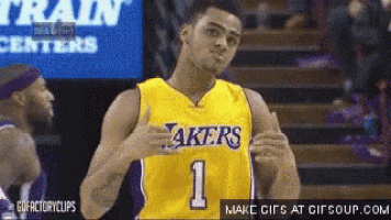 a basketball player wearing a lakers jersey is giving a thumbs up