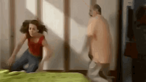 a man is pushing a woman on a bed .
