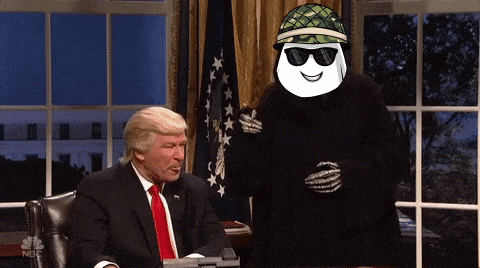 a man in a suit and tie is sitting at a desk next to a marshmallow wearing sunglasses