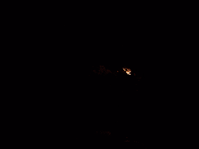 a person is blowing fire out of their mouth in the dark