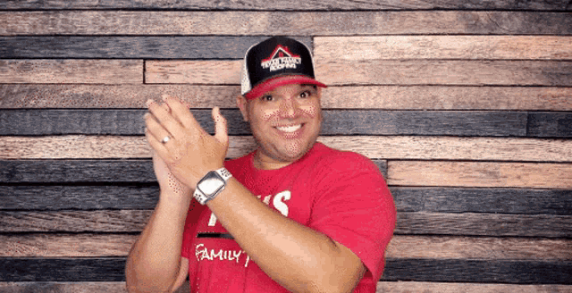 a man wearing a red shirt that says family is clapping