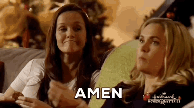 two women are sitting on a couch and the word amen is on the bottom