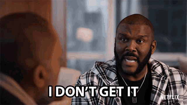 a man in a plaid shirt is talking to another man and saying i do n't get it .