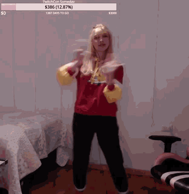 a woman in a red sweater is dancing in a room with a twitch con someday notification