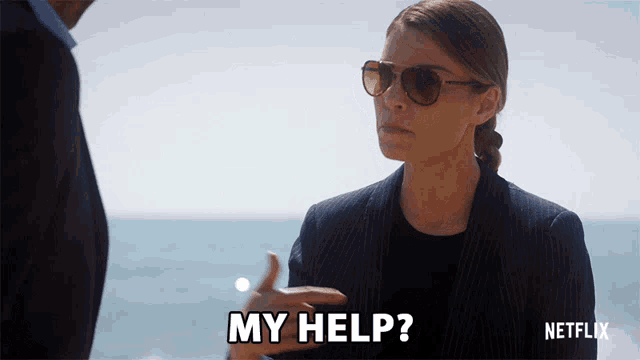 a woman wearing sunglasses says my help