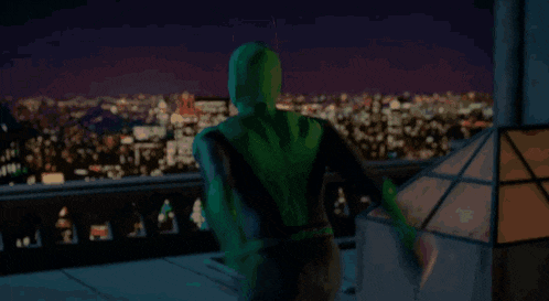 a man in a superhero costume is holding a green light