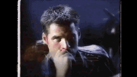 a close up of a man 's face with his hand on his mouth .