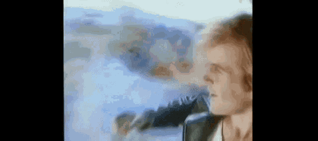 a close up of a man 's face in a blurry photo with a painting in the background .