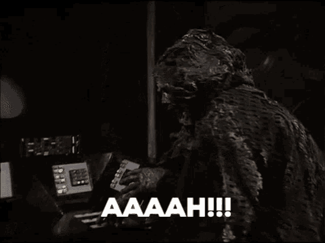 a zombie is standing in front of a computer screen and says aaah !!!