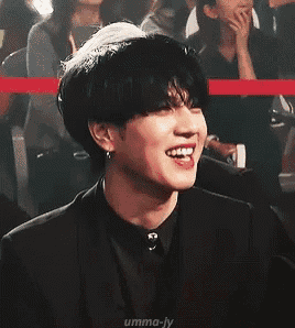 a man in a suit and tie is smiling in a crowd of people .