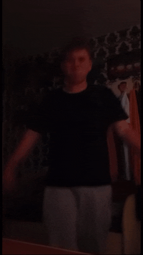 a person standing in a dark room with their arm up