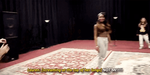 a woman is screaming at the top of her lungs while standing on a rug on a stage .