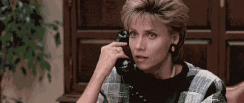 a woman is talking on a cell phone in a room .