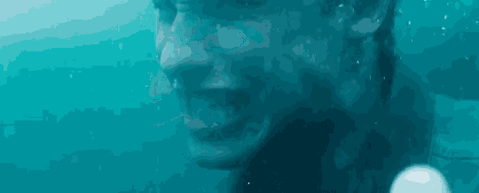 a close up of a man 's face underwater in the ocean .