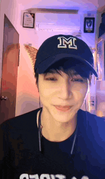 a young man wearing a black hat with the letter m on it