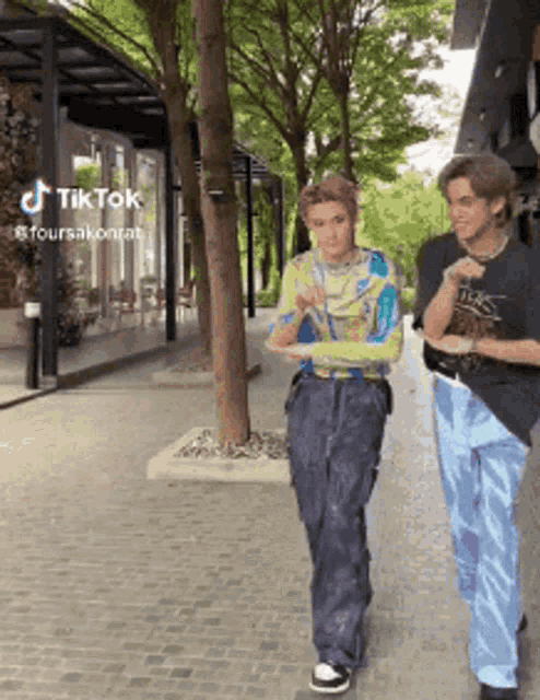 two men are walking down a street with a tiktok watermark on the bottom right