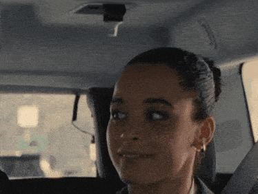 a woman is sitting in the back seat of a car smiling