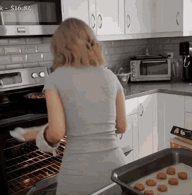 a woman cooking in a kitchen with a price tag that says $ 16.84 on it