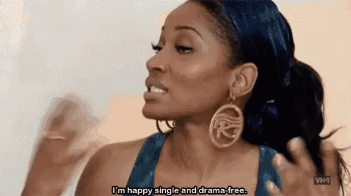 a woman wearing earrings and a headband is saying `` i 'm happy single and drama-free '' .