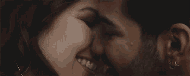 a man and a woman are kissing in a close up .