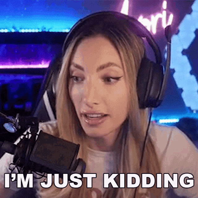 a woman wearing headphones and a microphone is saying i 'm just kidding .