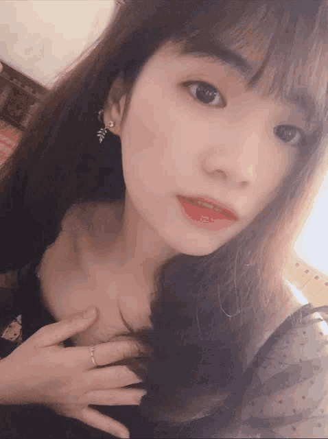 a woman with a ring on her finger looks at the camera
