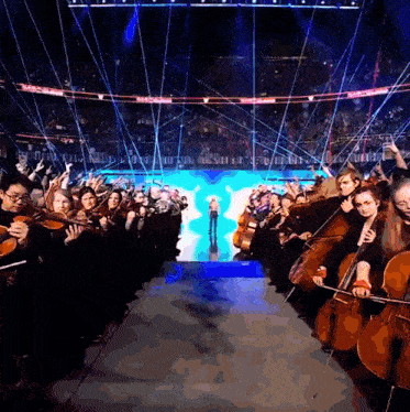 a group of people playing violins and cello in a stadium with a sign that says ' nba '