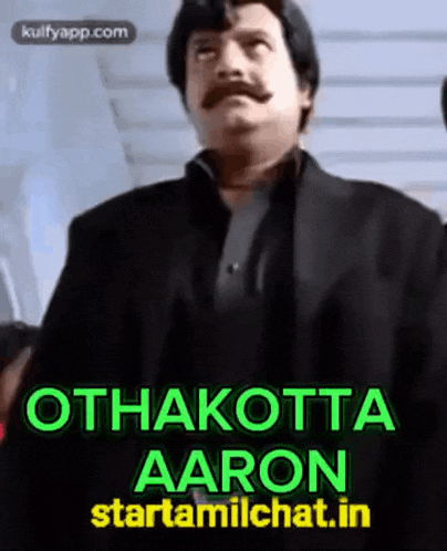 a man with a mustache is standing in front of a sign that says othakkotta aaron starttamilchat.in
