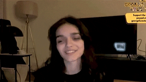 a woman is smiling in front of a television .