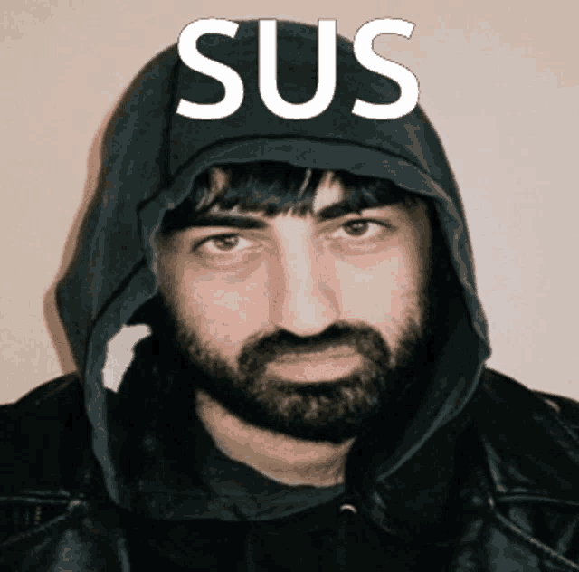 a man with a beard is wearing a black hoodie with the word sus written on it