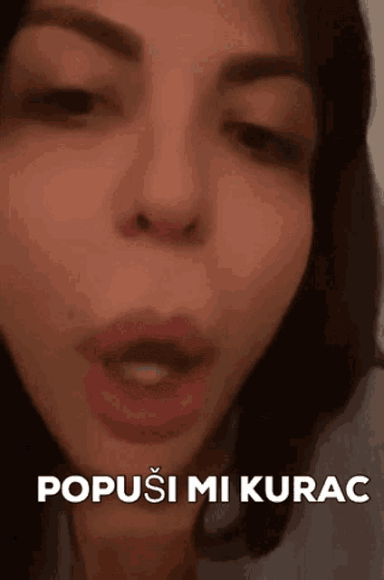 a close up of a woman 's face with the words " popusi mi kurac " above her