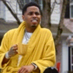 a man in a yellow robe is drinking from a cup