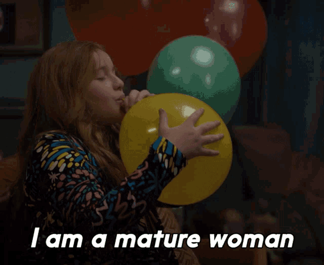 a woman blowing up a yellow balloon with the words " i am a mature woman " below her