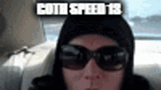 a person wearing sunglasses and a hood with the words goth speed 13 on top of them