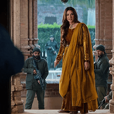 a woman in a yellow dress stands in front of a group of soldiers