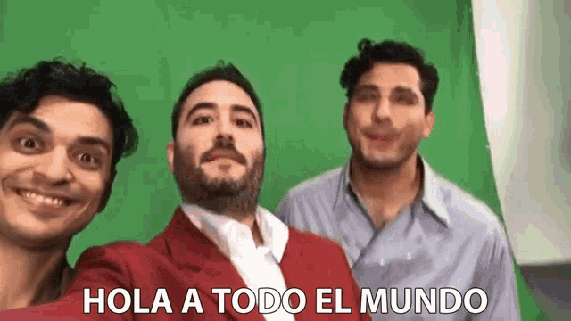 three men are posing for a selfie with the words hola a todo el mundo in the corner