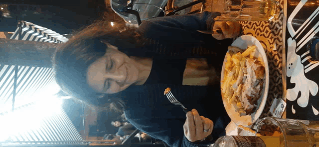 a woman sitting at a table with a plate of food