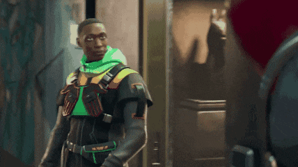 a man in a futuristic outfit with a green hood is standing in a doorway