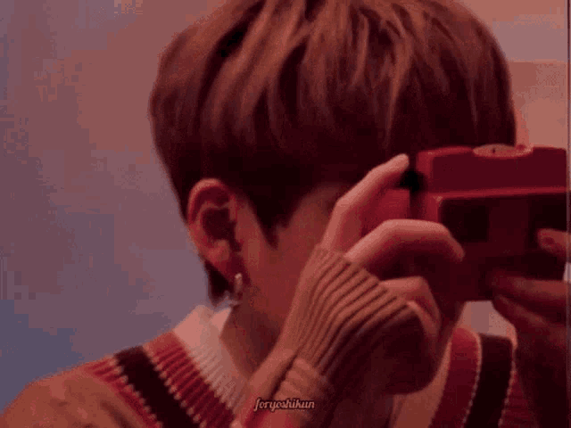 a man is taking a picture with a red camera .