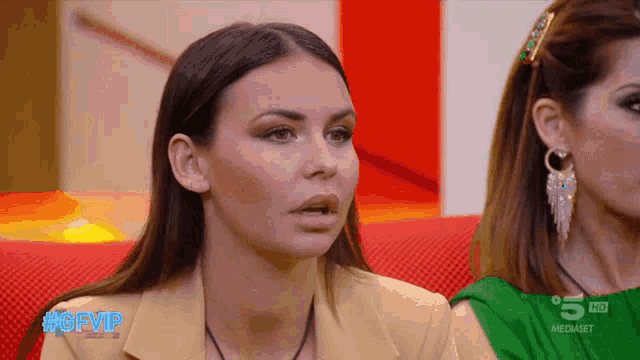 two women are sitting in front of a screen that says gfvip