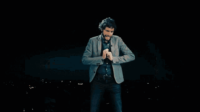a man with his arms outstretched in front of a dark background
